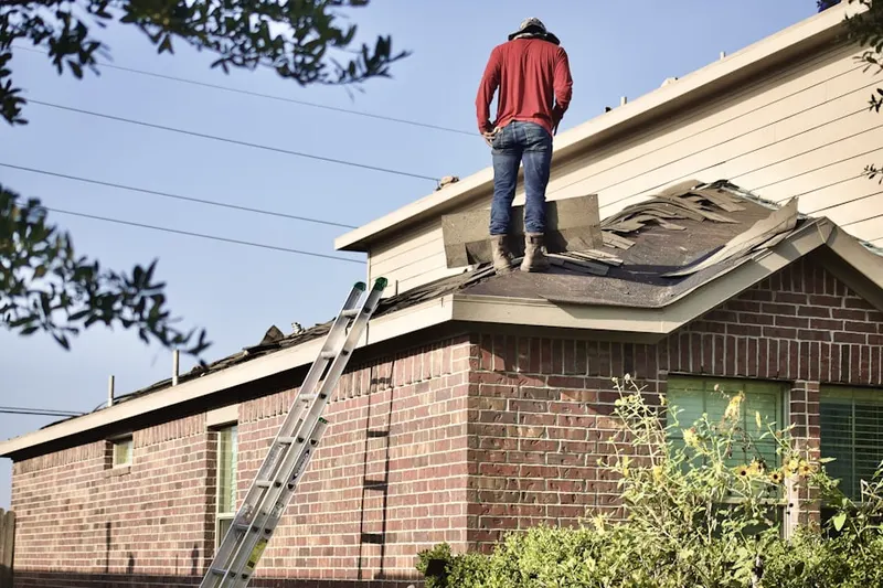 Professional roofer working on a residential roof in John Char Estates